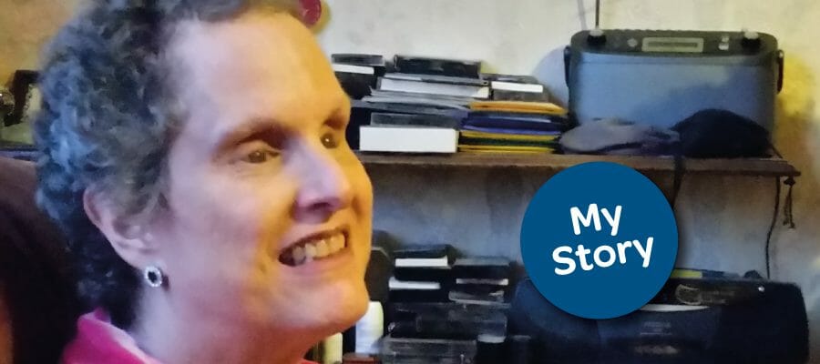 Eve Smyth sitting in her living room. The text reads, My Story.