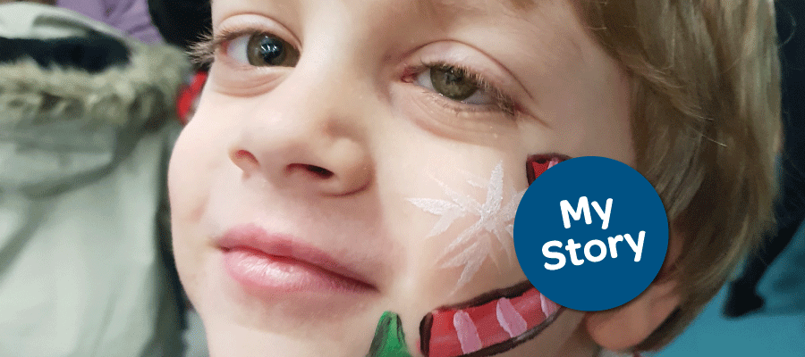 Noah with Christmas face paint on his left cheek.