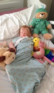 James in his hospital bed recovering from surgery. There is a bandage over his left eye.