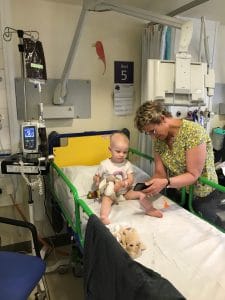 Amber in her hospital bed. Her hair has fallen out.