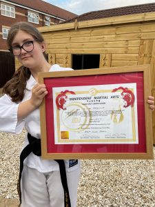 Olivia receives her black belt certificate in taekwondo
