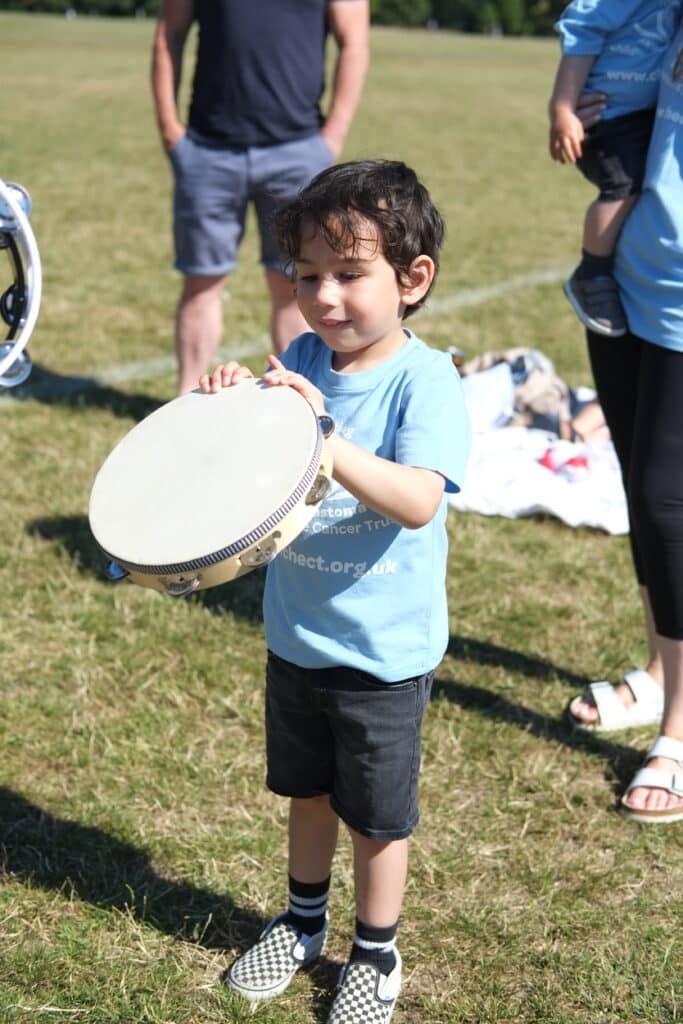 A boy in a CHECT T shirt with musical instruments