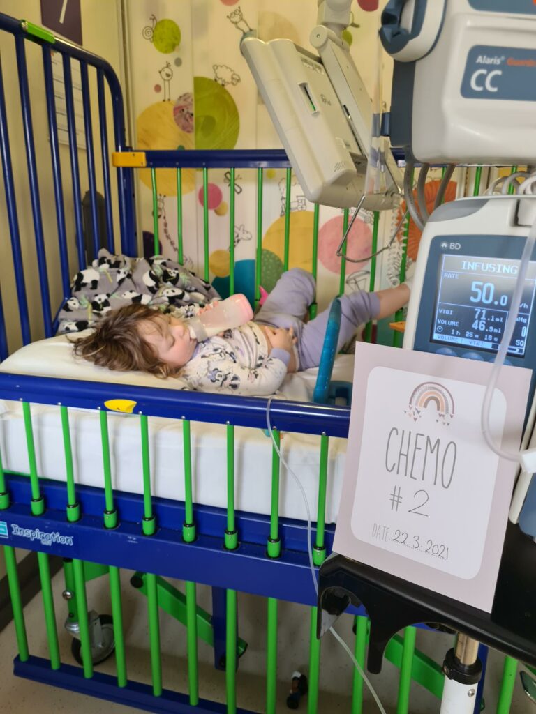 Darcey-Rose in a hospital bed drinking milk