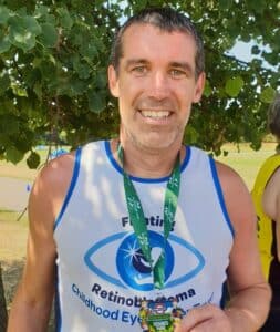 Phil smiling holding his medal