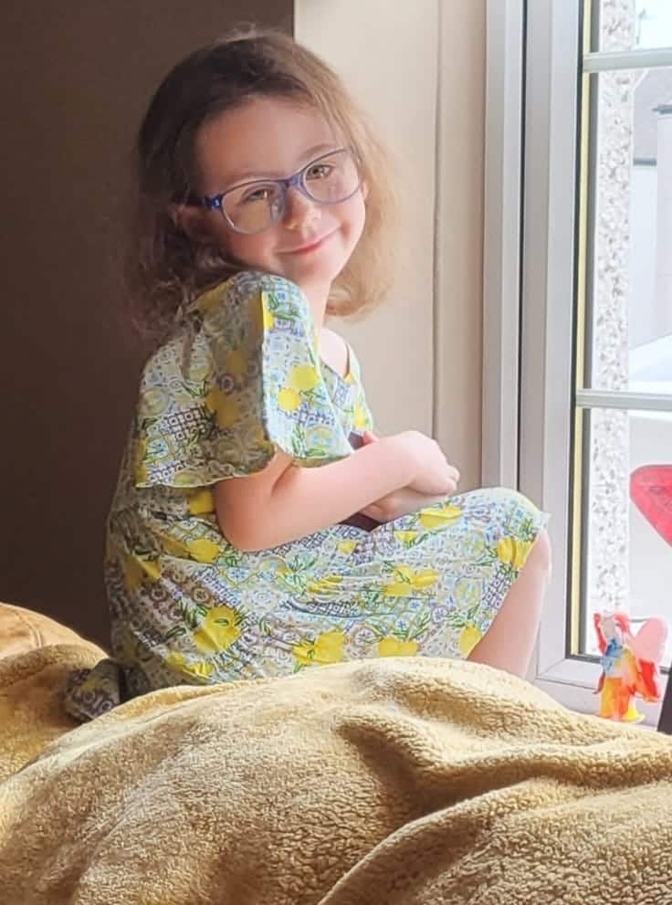 Bonnie sat by a window wearing her Frozen glasses