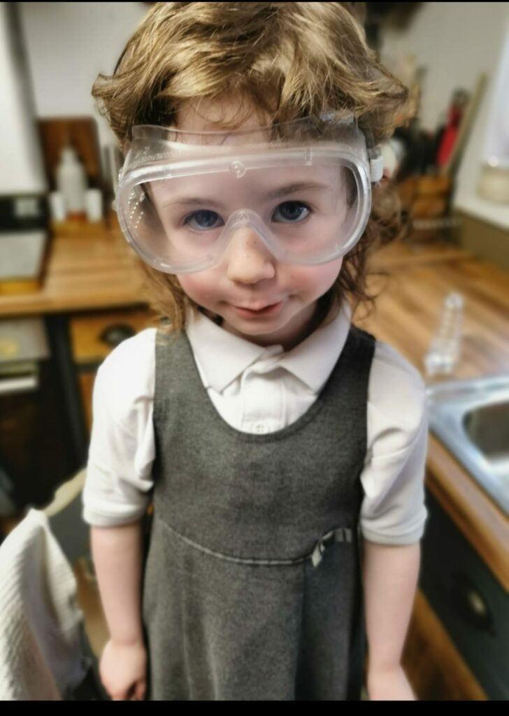 Bonnie wearing her safety goggles in her school uniform 