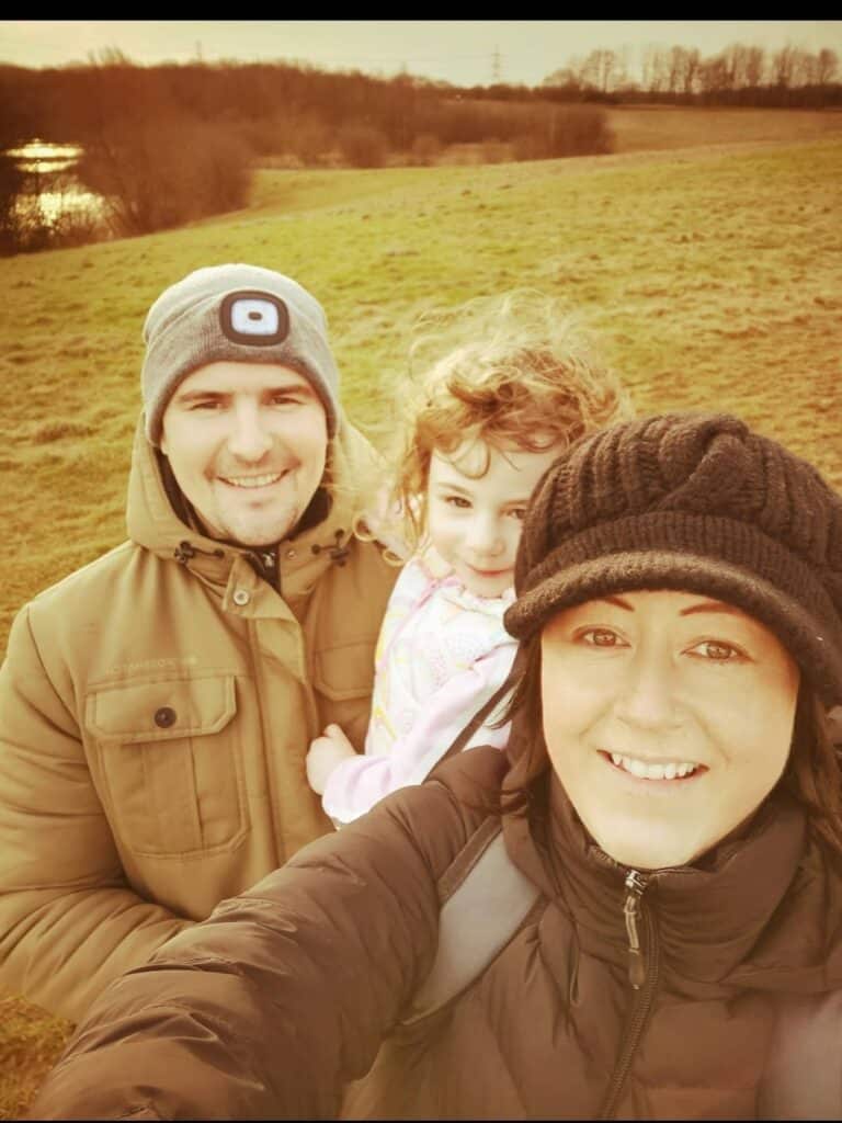 Bonnie outside smiling with her mum and dad