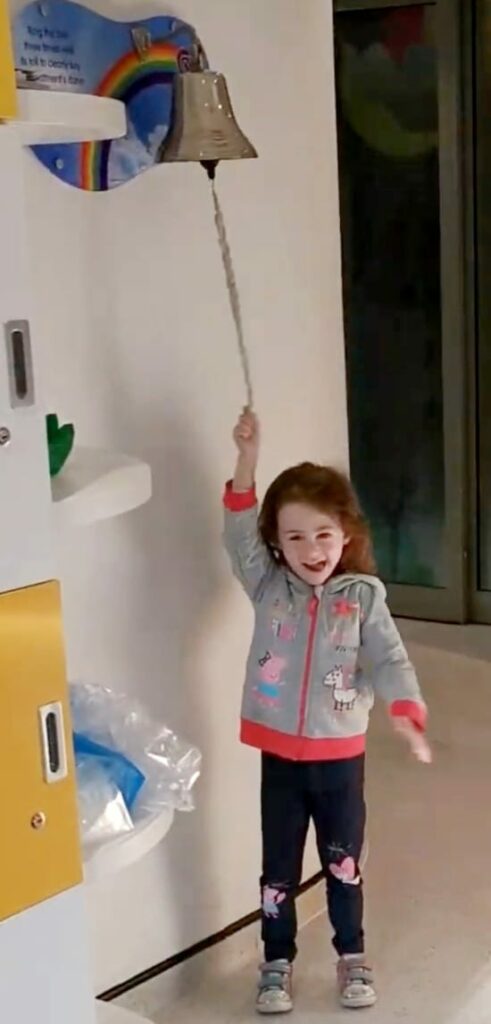 Bonnie smiling, ringing the bell at hospital 