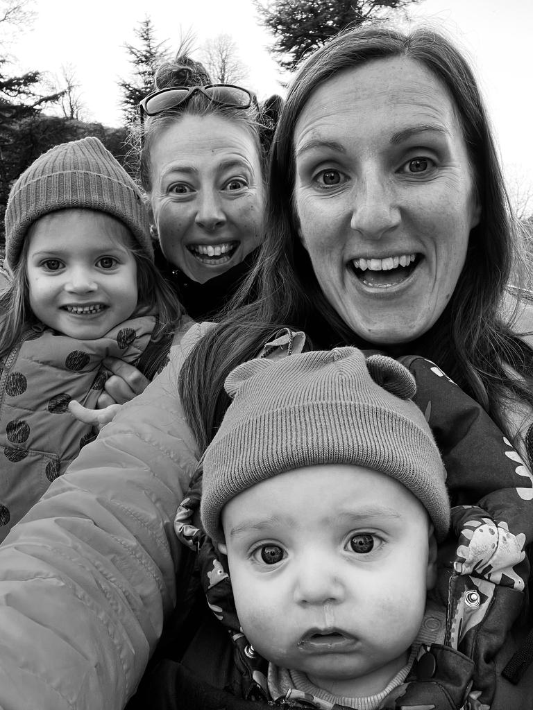 Isla, her parents and baby Theo smiling outside after treatment for  retinoblastoma - eye cancer