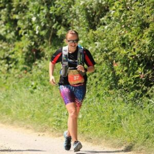 Gemma is running next to some hedges