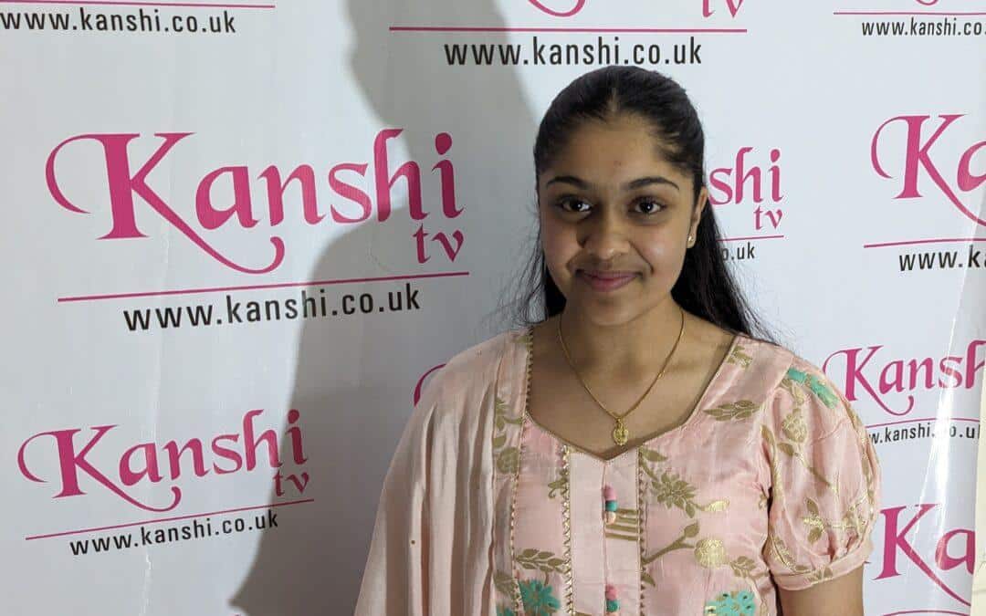 Armanie is stood in front of the Kanshi TV back drop