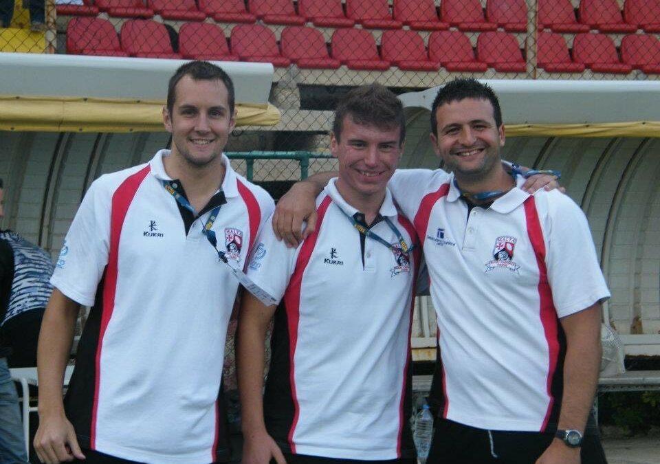Steven and his friend are in a rugby kit smiling at the camera at a stadium