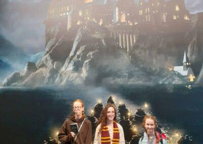 Three CHECT members under the image of hogwarts castle