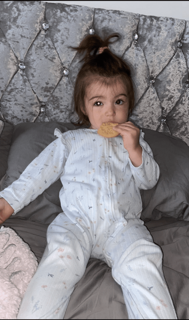 Evie is eating a biscuit, she has a glow in her eye