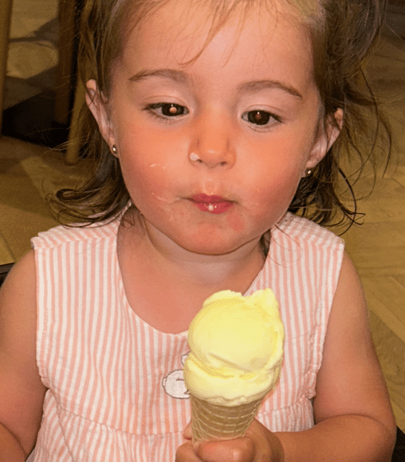 Evie is eating an ice cream. You can see the white glow in her eye.