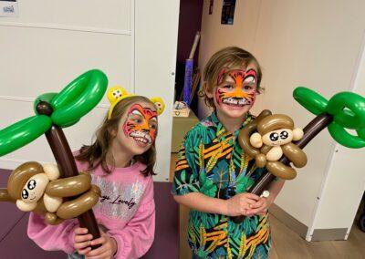 Two super cute kids with tiger face paint and monkey balloon animals at our Glasgow Science Centre event
