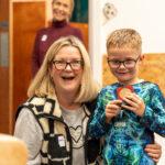 CHECT support worker Sarah and a boy smiling at the camera