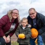 A family holding pumpkins