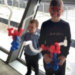 Two boys are holding balloons