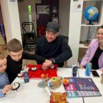 A family are gathered around a table doing experiments