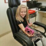 Frankie smiling with a pink camera