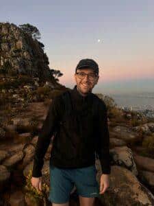 Cal is stood by the sea and sunset