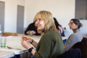 A smiling member sat at a table