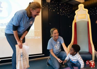 Two CHECT support workers with a CHECT Champion, laughing and smiling together!