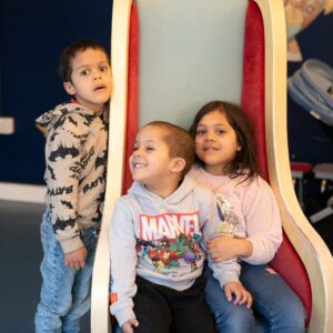 Three children are sat on a chair