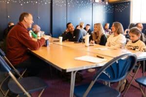 A group are smiling around a table