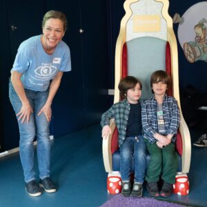 Two boys are sat on a chair
