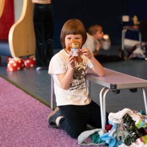 A boy is smiling with a CHECT teddy