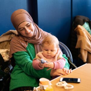 A mum is smiling at her baby