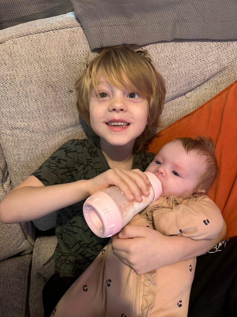 Arlo feeding his baby sibling milk