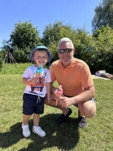 Daniel and George are outside in the sunshine smiling