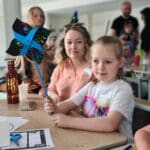 A girl is showing her paper windmill
