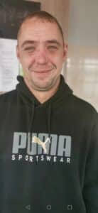 Stephen is wearing a Puma hoody and smiling