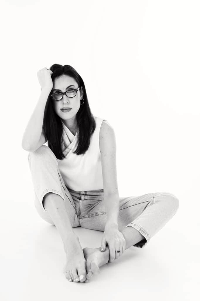 Ana is sat on the floor, the photo is in black and white