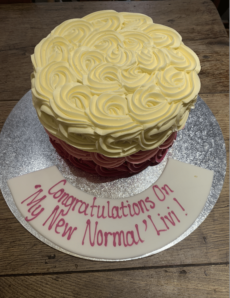 A cake that reads 'Congratulations on 'My New Normal' Livi!