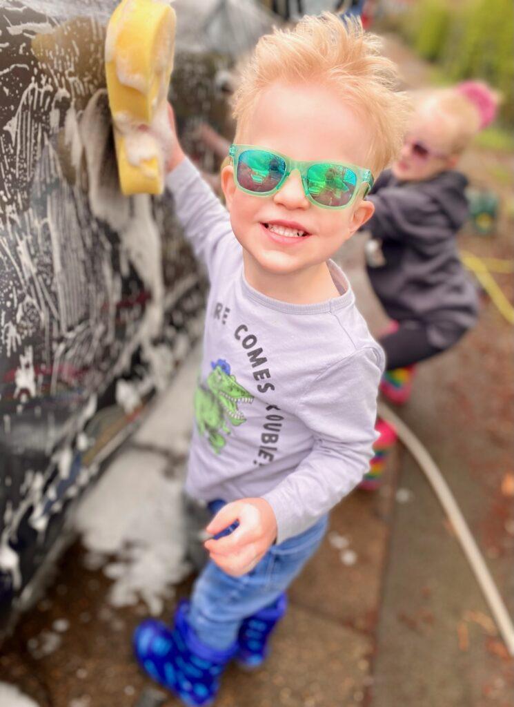 Thomas smiling, washing a car