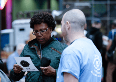 Wunderman Thompson volunteer handing out leaflets to a member of the public whilst volunteering for CHECT