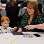A mum and son are smiling and drawing