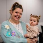 A mum is proudly holding her baby