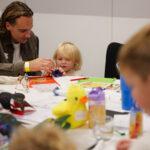 A dad is doing crafts with his toddler