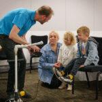 A museum worker is talking to a family