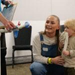 A mum and toddler are sat on the floor, smiling