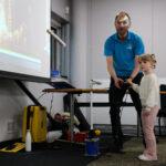 A child is with a museum worker, using a projector