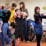 Children have their hands in the air smiling