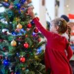 A child touching a bauble on a Christmas tree