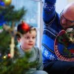 A child next to a Christmas tree